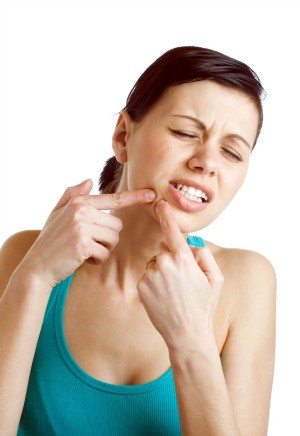 A girl popping a pimple.