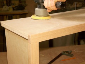 Sanding an oak plywood cabinet.