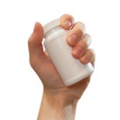 Photo of a hand holding a supplement bottle.