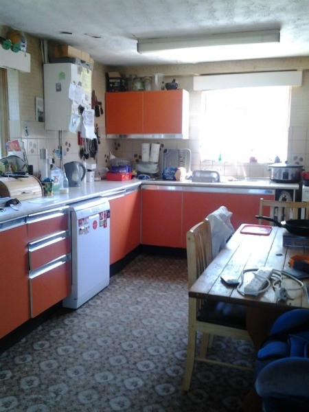 Kitchen with orange cupboards.