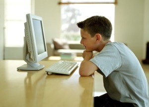 A boy using a computer in the living room.