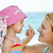 A mom putting sunscreen on her child.