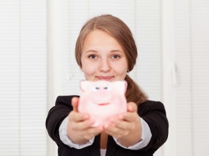 Teen girl holding a pink piggy bank.