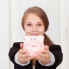 Teen girl holding a pink piggy bank.