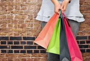 A teen holding 4 clothes shopping gags.