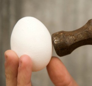 Egg being tapped with a hammer.