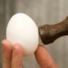 Egg being tapped with a hammer.
