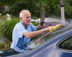 A man cleaning his car windows.