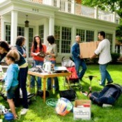 Yard sale on the front lawn of a house.