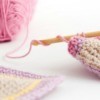 Crochet hook and pink yard.