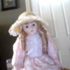 Doll in pink dress with ringlets in hair.