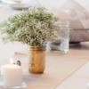 Wedding table with baby's breath in gold mason jars.