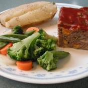 Square of meatloaf with vegetables.