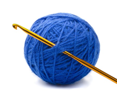 Ball of blue yarn with crochet hook.