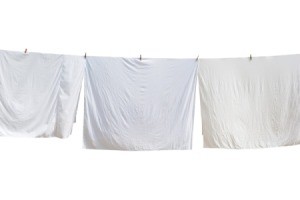 Bed Sheets hanging on a line.