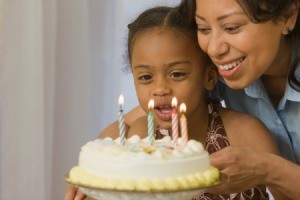 Four year old blowing out birthday candles.