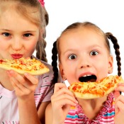 Two girls eating pizza.