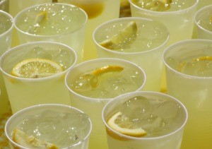 Lemonade cups on a table for serving to a large group.