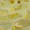Lemonade cups on a table for serving to a large group.