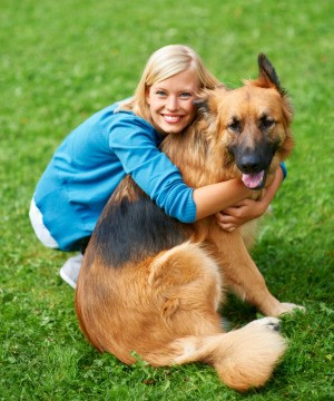 A dog owner hugging her dog.