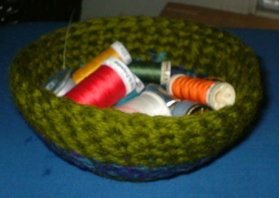 Bowl filled with spools of thread.