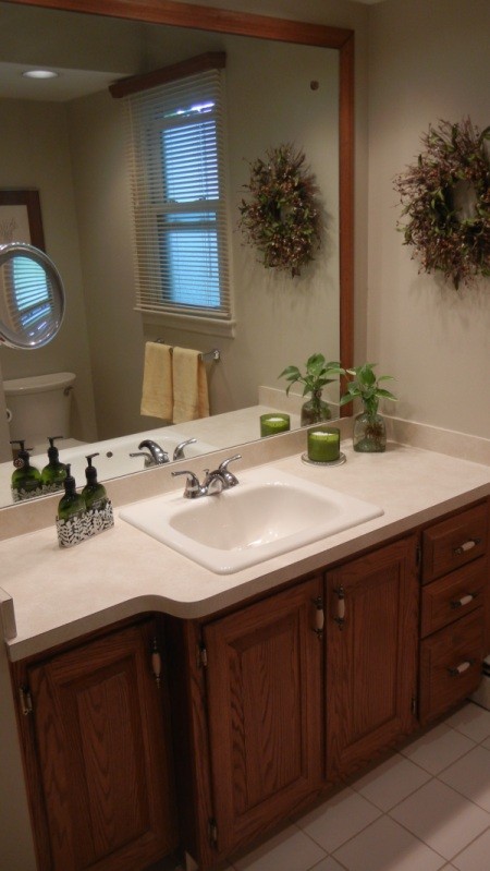 A beige bathroom with a large mirror.