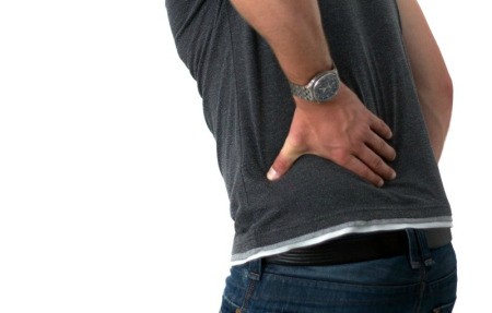 Young man holding his lower back.