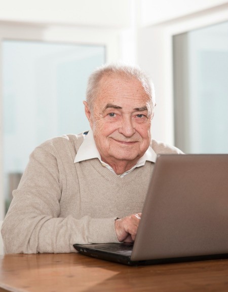 A senior man using a computer.