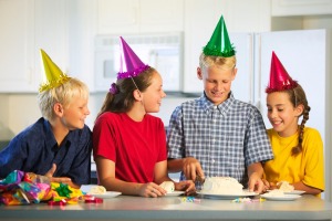 Kids gathered around cake at birthday.