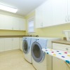 Modern laundry room with front load washer,dryer, and ironing board.
