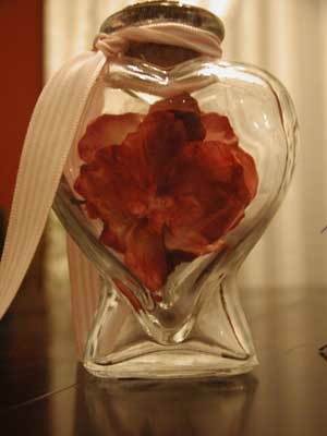 Heart shaped bottle with red flower.