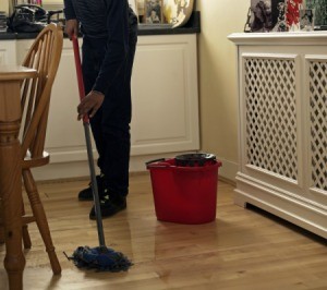 Mopping a wood floor with oil soap.