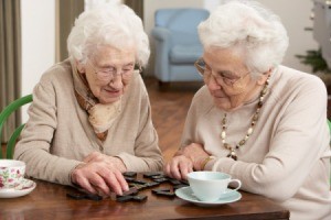 Two elderly women playing dominos.