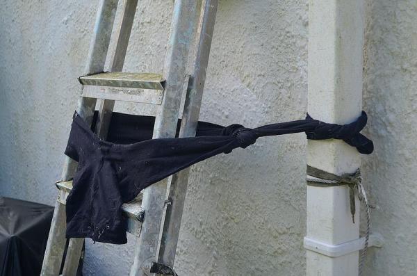 Pair of tights used to tie off ladder to down spout.