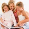 A babysitter reading to two girls.