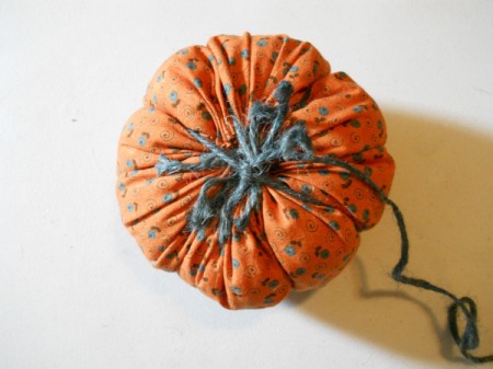 Creating veins in pumpkin by tying jute.