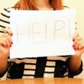 A woman holding a help sign.