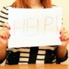A woman holding a help sign.