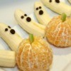 Halloween treats made from bananas and oranges. The oranges look like pumpkins and the bananas look like ghosts.