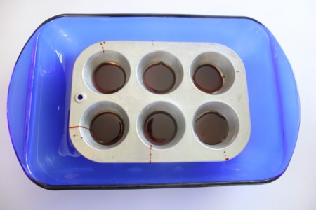 Muffin pan with caramel in each cup.