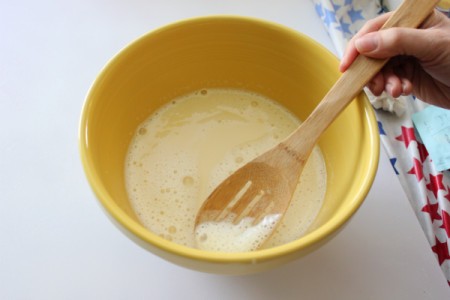 Removing froth from custard mixture.