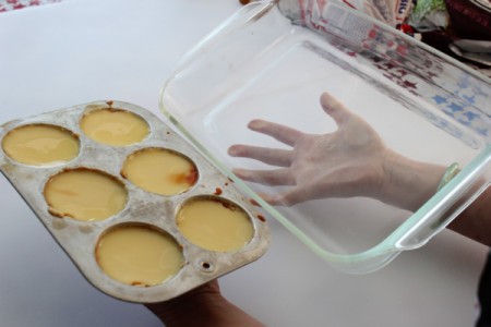 Hands holding rectangular glass baking dish and muffin pan.
