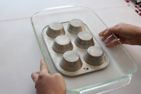 Inverted muffin pan in glass baking dish.