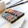 A picture of watercolor paints and paint brushes.