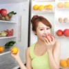 A teen girl eating fruit.