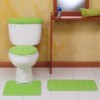 A white toilet with a green toilet seat cover.