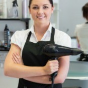 Photo of a hair stylist holding a blow dryer.
