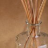 Reed diffuser with reeds in a jar containing scented oil.