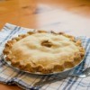 An apple pie with a delicious looking pie crust.