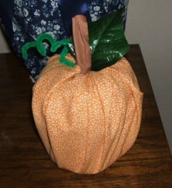 A decorative pumpkin created from a toilet paper roll.